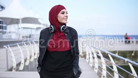 一个年轻的穆斯林女孩在海边散步享受她的空闲时间在户外慢镜头视频的预览图