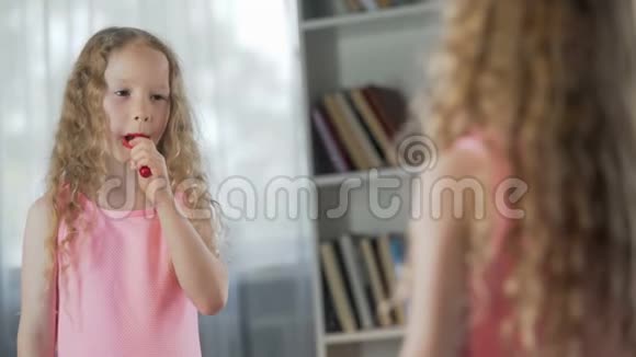 小女孩化妆前在镜子前涂口红视频的预览图
