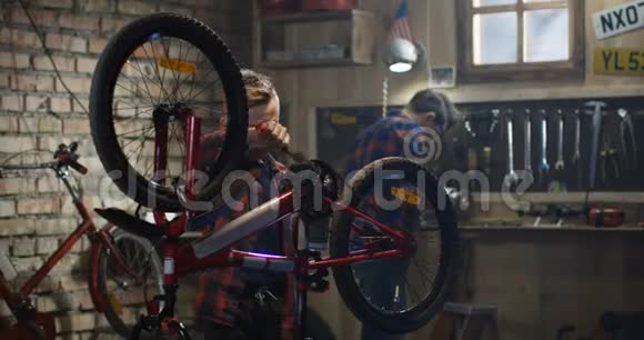 两个男孩在车库里修自行车视频的预览图