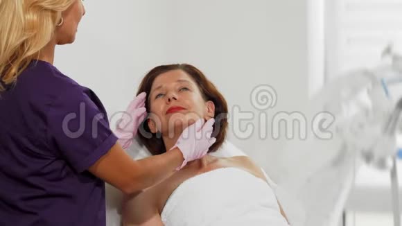 专业美容师检查一位老年女性患者的皮肤视频的预览图