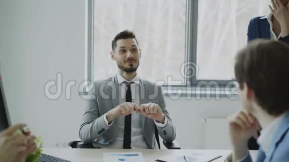 在现代办公室里商务男女同事在休息时一边笑一边说话视频的预览图