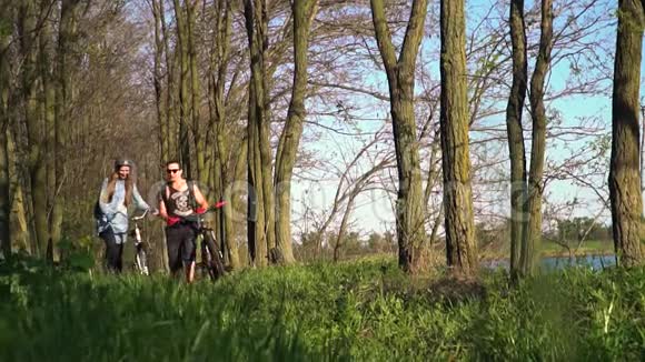 一对可爱的骑自行车的人在树林里慢悠悠地走着视频的预览图