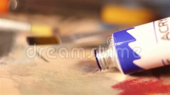 艺术家把蓝色的颜料从管子里挤到调色板上视频的预览图