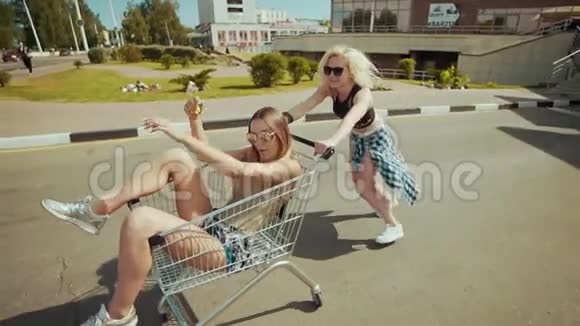 年轻的时髦少女们在停车的时候玩着购物车视频的预览图