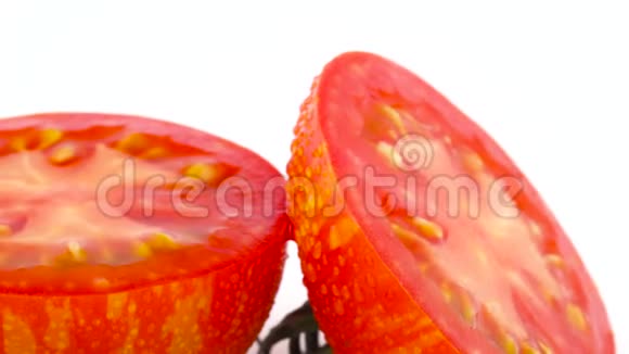 宏观射击红球条纹番茄的横截面两半在转盘上慢慢旋转隔离在视频的预览图