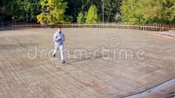 男人跑下来然后在公园里上了一套楼梯男人在公园里慢跑楼梯视频的预览图