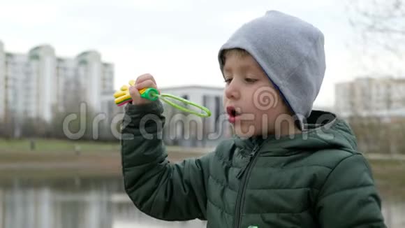 小河边有泡泡的小男孩在户外视频的预览图