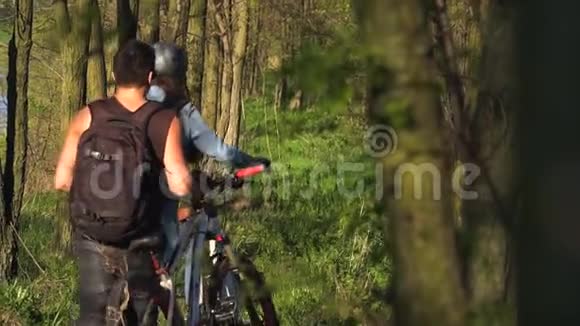 后视为一对骑自行车的人在公园里骑自行车动作缓慢视频的预览图