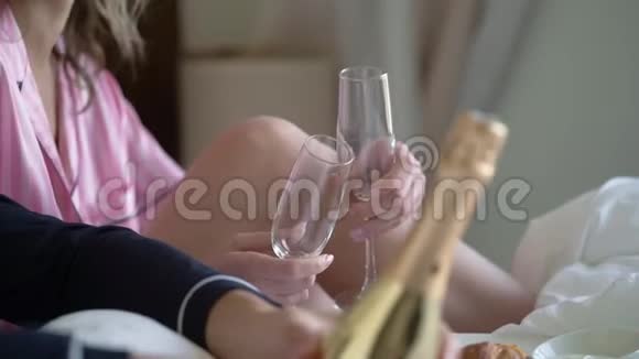 年轻夫妇打开一瓶香槟在家里倒杯酒精饮料和饮料视频的预览图