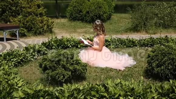 一个小女孩在公园的草地上看书视频的预览图
