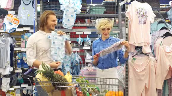 幸福夫妇在购物中心选择婴儿服装视频的预览图
