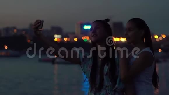 两个女朋友晚上在灯光背景下自拍慢动作视频的预览图