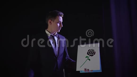 魔术师用一朵画好的花表演魔术魔术师改变画中图片的颜色与魔术师视频的预览图