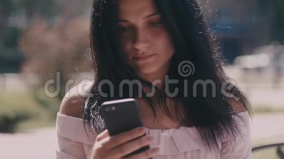 使用智能手机在夏季城市街道上的年轻女士肖像视频的预览图