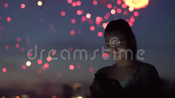 一个女孩在烟火中使用萨特电话4K视频的预览图