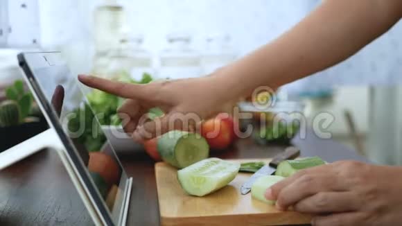 4K女人用手指在平板电脑上滑动剥黄瓜准备烹饪原料然后在网上烹饪视频剪辑视频的预览图