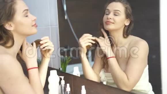 美丽的年轻女子照镜子浴室4k镜头视频的预览图