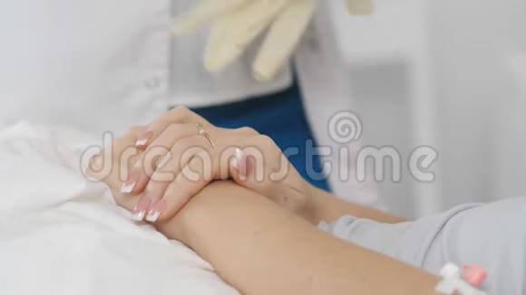 女医生安抚支持患者手术前女医生把手放在病人的手掌上视频的预览图