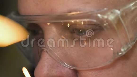 一个30多岁的人在眼镜特写中焊接并在4K内反射火花视频的预览图