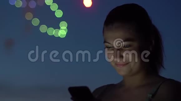 一个女孩在烟火中使用智能手机慢动作高清高清视频的预览图