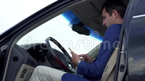 成功的商人正在汽车里通过电话进行商务交谈视频的预览图