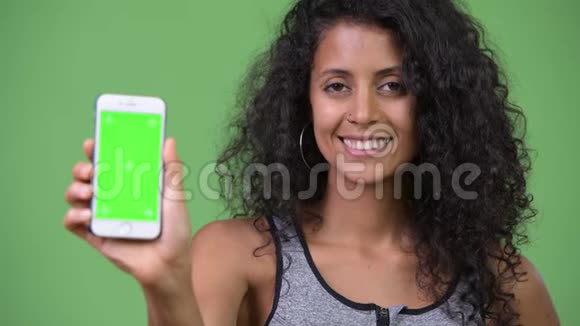 年轻漂亮的西班牙女人穿着运动服显示电话视频的预览图