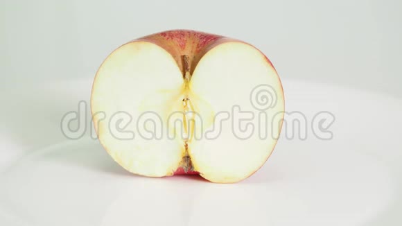 在白色盘子上切成两半的红苹果水果视频的预览图