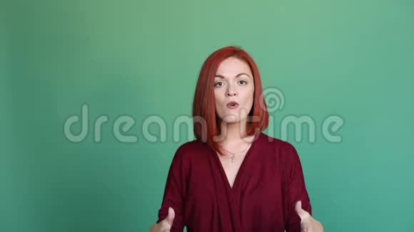 愤怒的红头发女人用手在镜头里做手势用不开心的脸说话视频的预览图