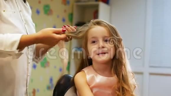 美发师是为小可爱女孩卷发使用电卷发铁投中弹视频的预览图