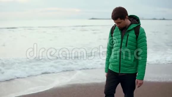 一个成年人在凉爽的时候在海滩上水在他的鞋上视频的预览图