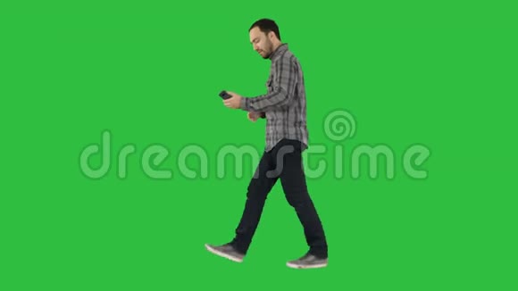 快乐的微笑走着英俊的胡须年轻人在绿色屏幕上自拍Chroma键视频的预览图