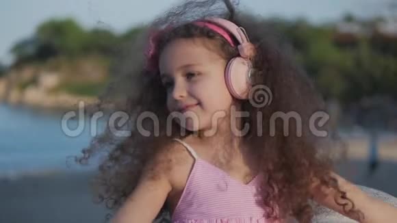 一个留着卷发的可爱的孩子的肖像穿着粉色衣服穿着粉色花朵的白种人小女孩夏天视频的预览图