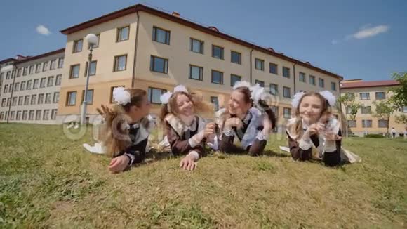 四名女学生在学校背景下躺在草地上俄罗斯学校视频的预览图
