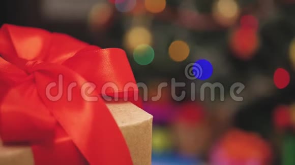 穿着红色裙子的女孩打开圣诞礼物带着圣诞礼物盒的快乐微笑的小女孩舒适温暖视频的预览图