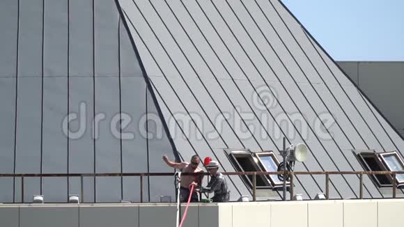 大楼屋顶上的两个人准备了吊索以防止松弛缓慢的运动视频的预览图
