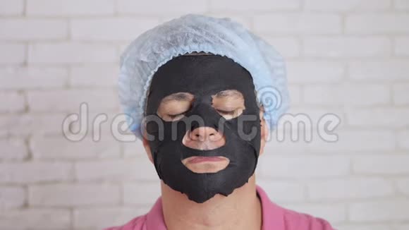 男人用一个恢复青春活力的黑色组织面膜洗脸吓得眼睛向两边眨视频的预览图