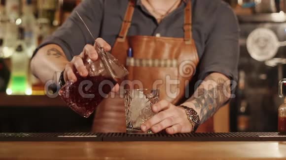 酒吧老板正把混合饮料倒在杯子里酒吧里放着一大块冰块视频的预览图