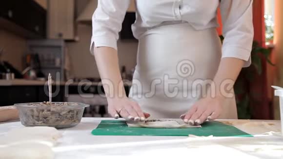穿围裙的女孩准备信封和蘑菇在家烤视频的预览图