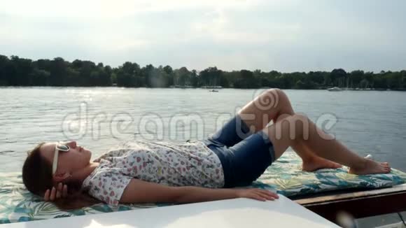 女孩躺在帆船游艇上享受大海在一艘大船上航行的海洋视频的预览图