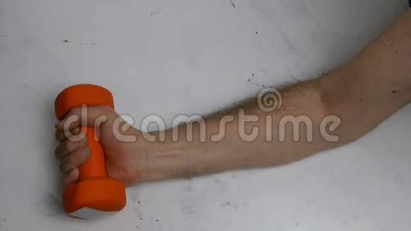 弱没有肌肉的男性手臂用橙色哑铃做运动视频的预览图