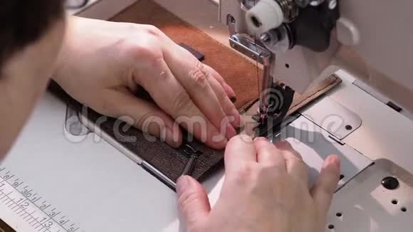 工匠在缝纫机上为皮手提包缝制口袋视频的预览图