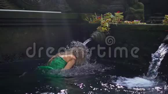 一名年轻女子在印度尼西亚参观冬青泉的慢镜头蒂塔恩普尔圣水泉在巴厘岛视频的预览图