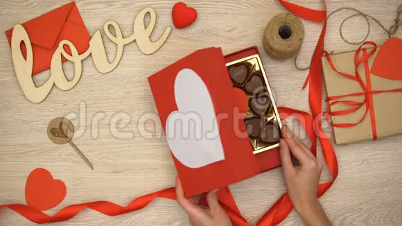 女士打开情人节礼品盒与心形巧克力糖果春药视频的预览图