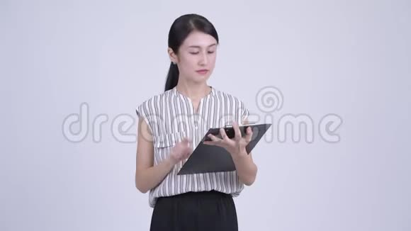 快乐的亚洲女商人展示剪贴板竖起大拇指视频的预览图