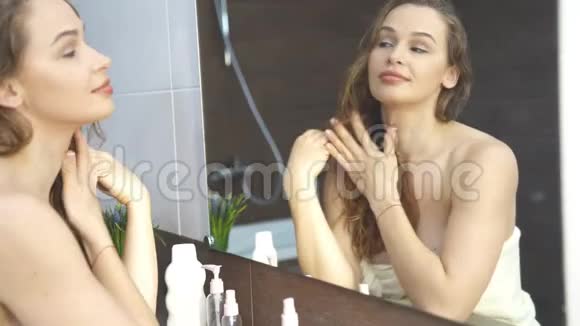 漂亮的年轻女子在浴室里照镜子视频的预览图