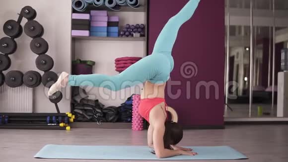 运动女孩举起腿瑜伽姿势平衡能量集中有哑铃的健身房健康生活方式视频的预览图