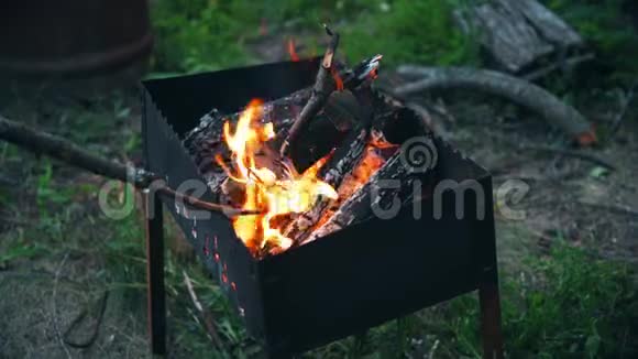 人们坐在火炉旁不时地用木棍在坟墓里翻燃柴火视频的预览图