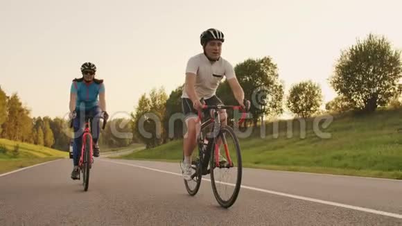 刻苦训练三项运动员两名自行车运动员公路自行车训练两个骑自行车的人在城市公园骑自行车视频的预览图