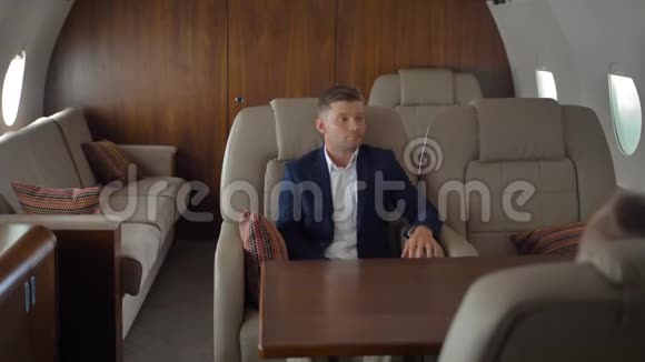 私人飞机内的商务人士在飞行和与空姐交谈时放松身心视频的预览图