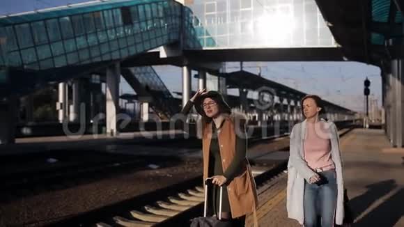 火车站站台上的乘客等待火车旅行前的谈话和兴奋视频的预览图